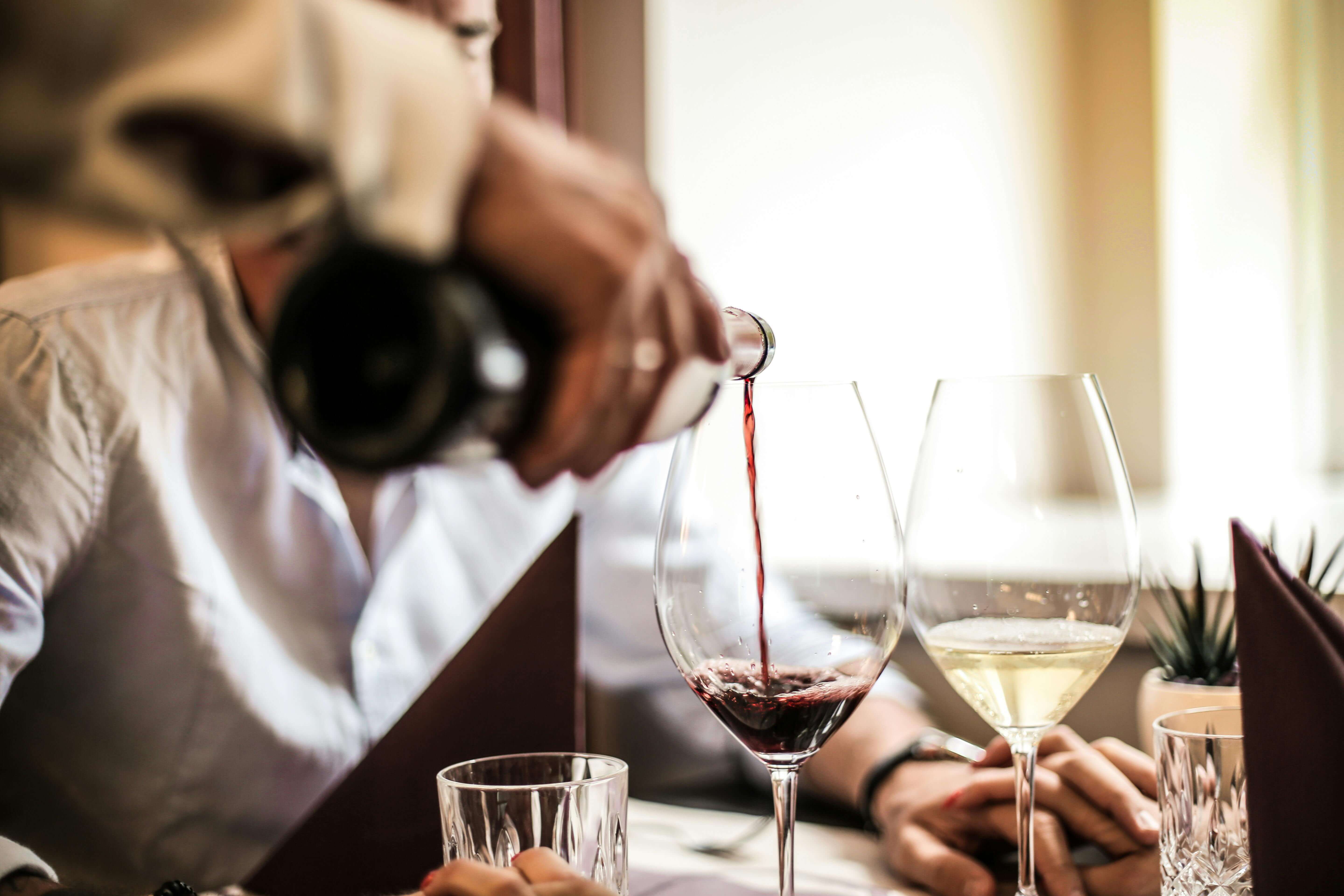 Waiter pouring wine in a fine dining restaurant