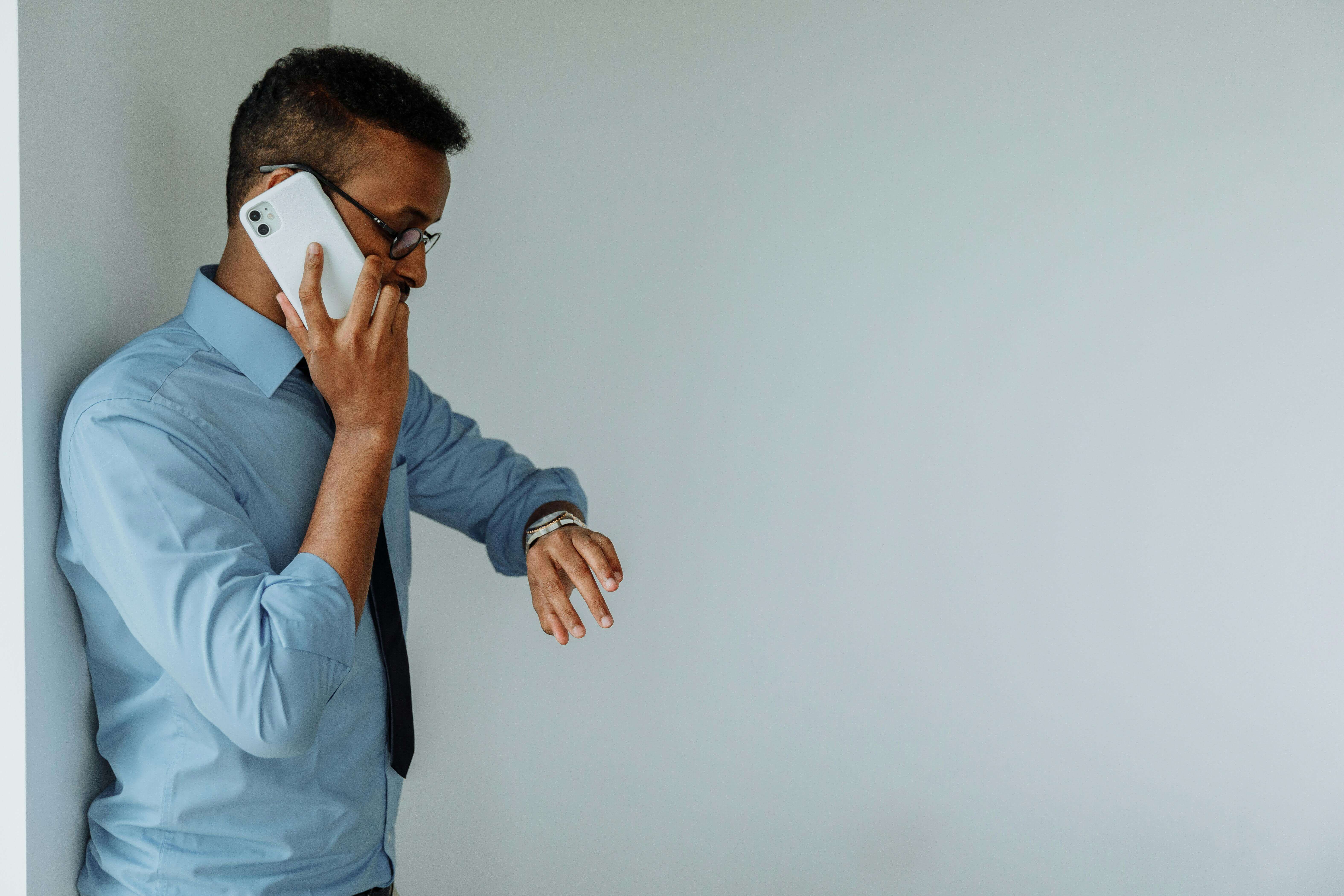 an escort client making a phone call to book and looking at his watch