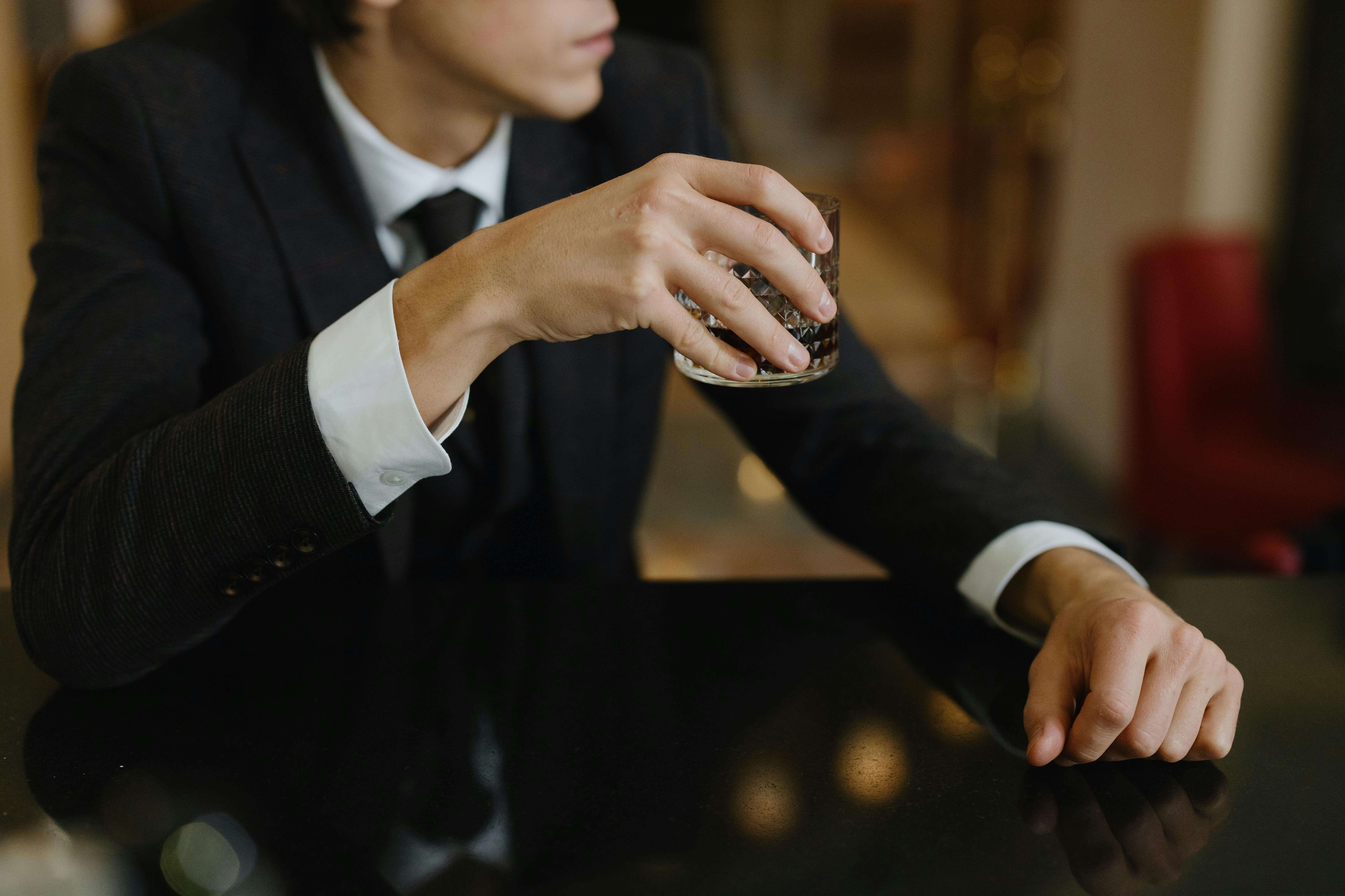 an escort client holding a drink at a bar